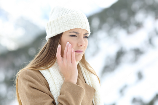 Femme en colère utilisant une crème hydratante protectrice en hiver dans une montagne enneigée